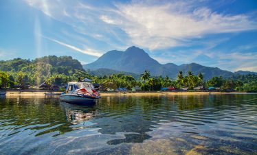 scenic tropical beach with speedboat and mountain view